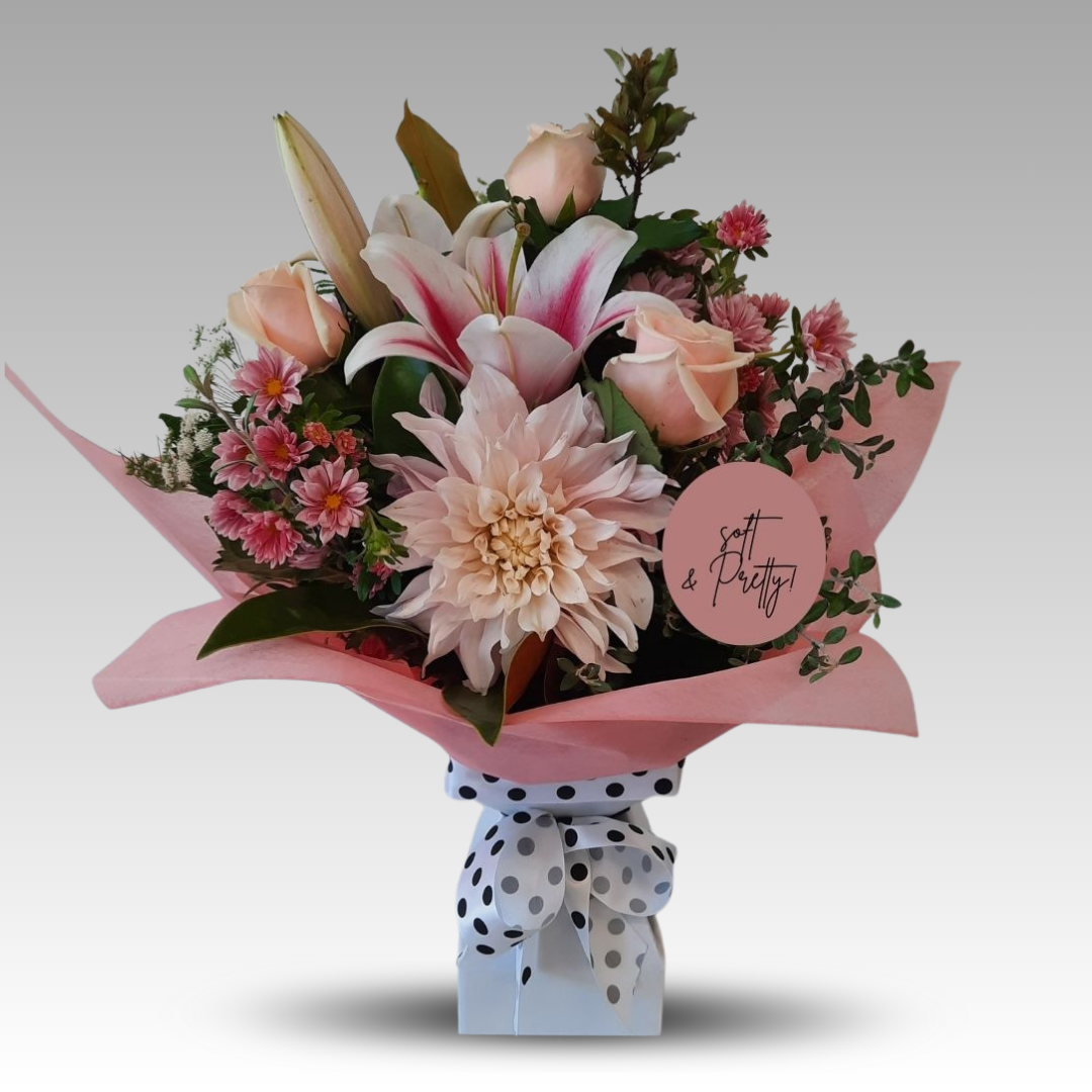 A bouquet of soft peach and blush blooms with a vintage charm