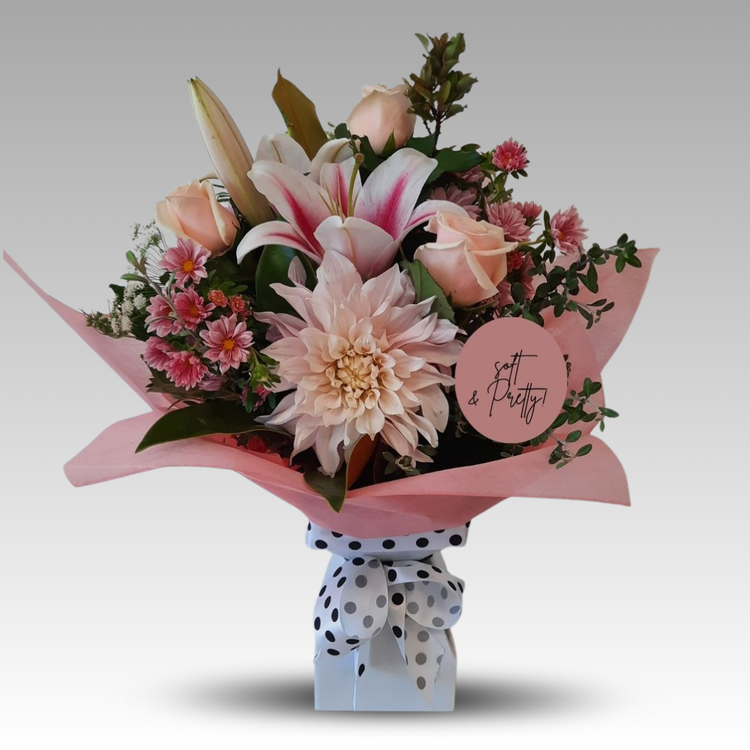 A bouquet of soft peach and blush blooms with a vintage charm