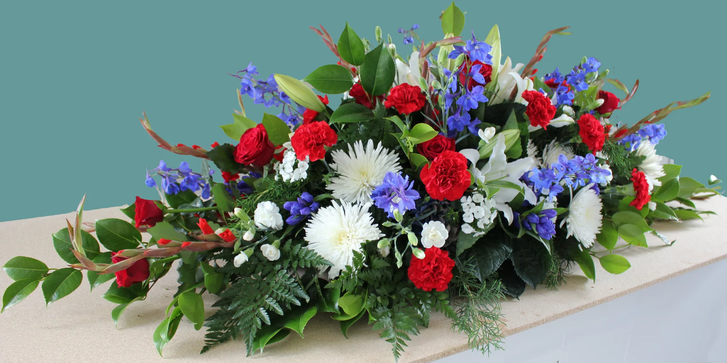 Large casket spray with red, white, and blue flowers